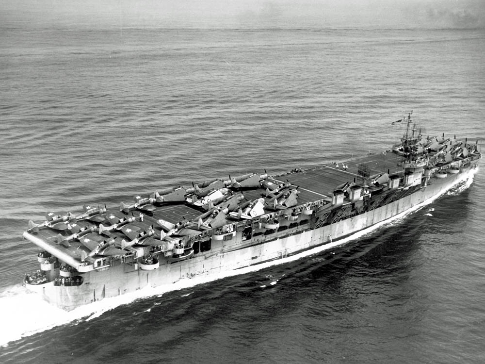 With the flight deck crowded with aircraft, the U.S. Navy Independence-class light aircraft carrier USS Cowpens (CVL-25) underway in the Pacific in July 1943. (U.S. Navy Photograph.)