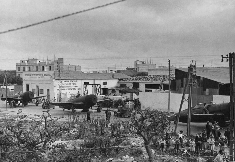 Tractor tugs tow Republic P-47 Thunderbolt fighters from the harbor to their airfield in North Africa. (U.S. Air Force Photograph.)