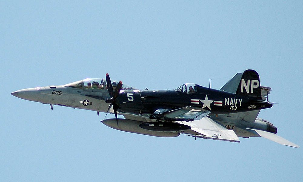 An F4U Corsair and an F/A-18 Super Hornet fly in a legacy fighter aircraft formation over Key West, Florida in preparation for the Centennial of Naval Aviation Celebration at Naval Air Station Key West. (U.S. Navy photograph by MCS 3rd Class Michael McNabb / Released.)