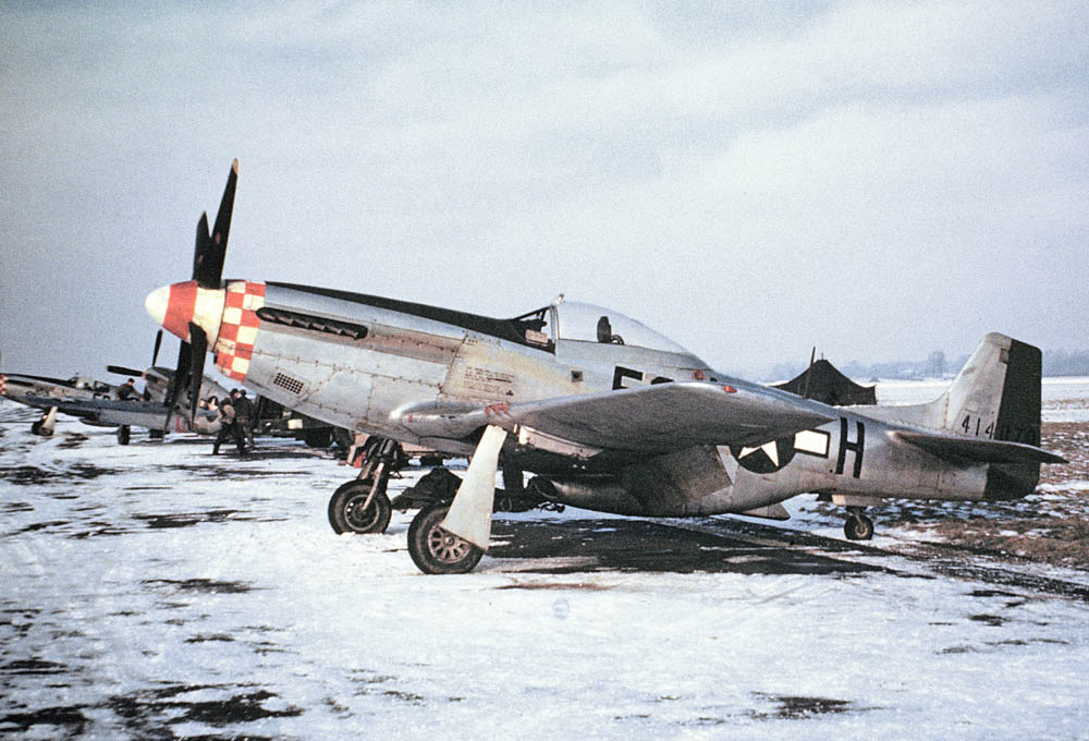 A colorful P-51 Mustang aircraft of the 339th Fighter Group is parked in the winter snow at RAF Bassingbourn in January 1945. (Collection Imperial War Museums.)