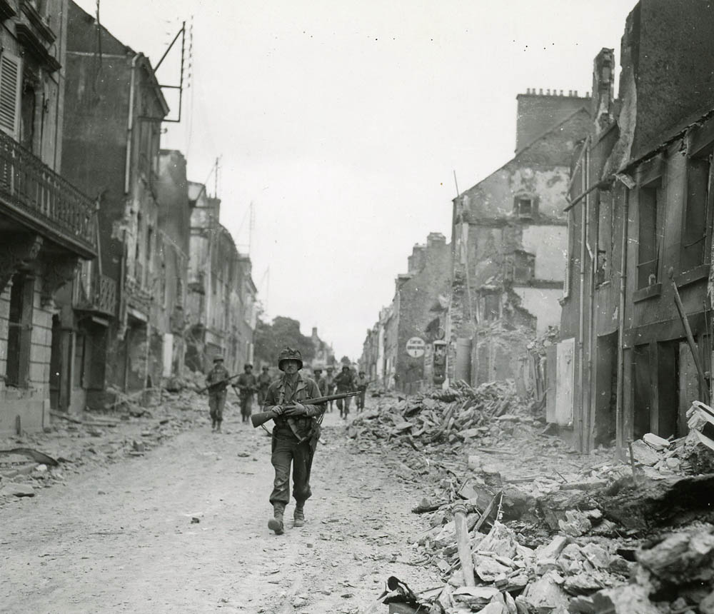Soldiers in the advance guard of the U.S. Army's 29th Infantry Division march into St. Lo, France on July 20, 1944. The 29th ID captured the city as part of the XIX Corps of the First Army. (U.S. Signal Corps Photograph.)