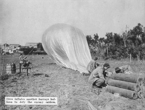 [Crew inflates another barrage balloon to defy the enemy raiders.]