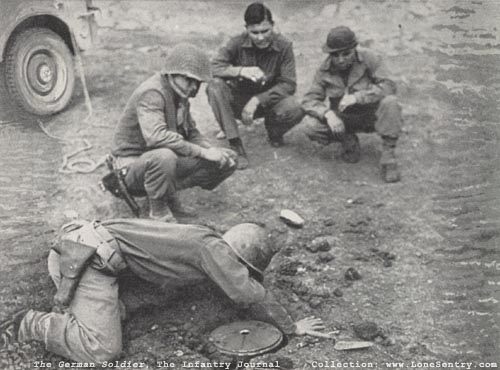 [US soldier lifts German Teller mine]