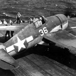 Sailors on the USS Hornet fold the wings of a Grumman F6F Hellcat fighter after a raid over the Marianas, June 1944.