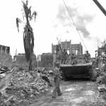 U.S. Marines ride an armored vehicle through Garapan on the island of Saipan in the Mariana Islands, June 1944. (U.S. Marine Corps Photograph.)