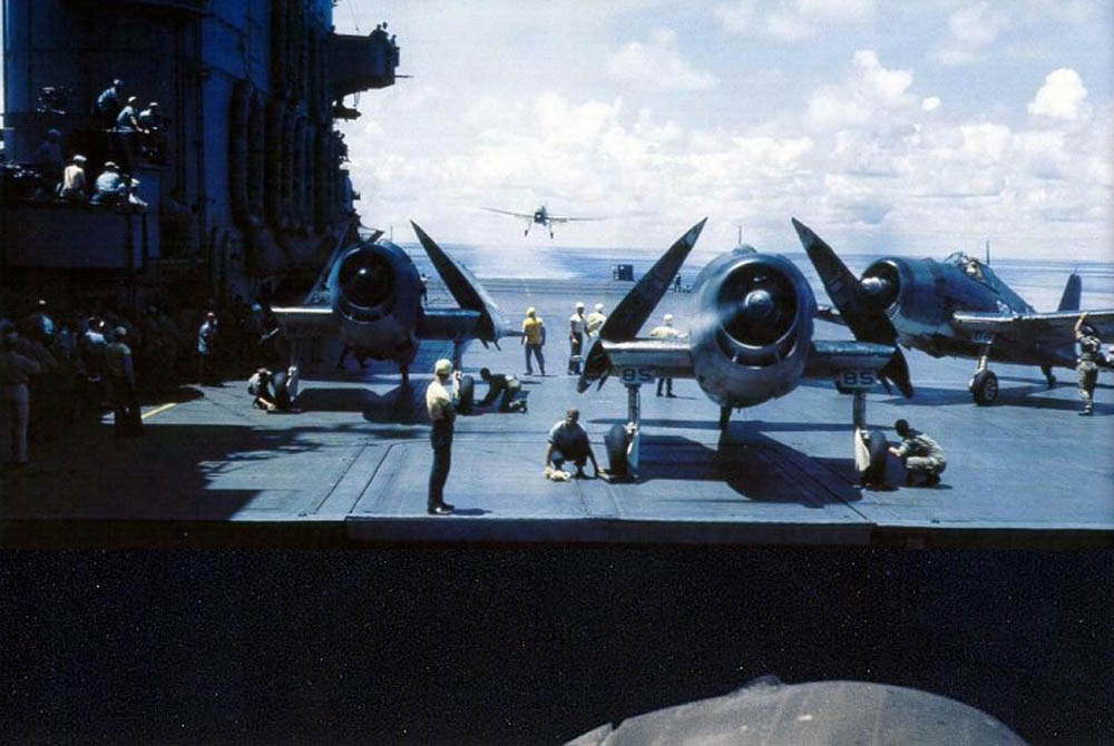 Grumman F6F Hellcat fighters sit with propellers running and wings folded on the flight deck of the aircraft carrier USS Saratoga (CV-3) during World War II. (U.S. Navy Photograph.)