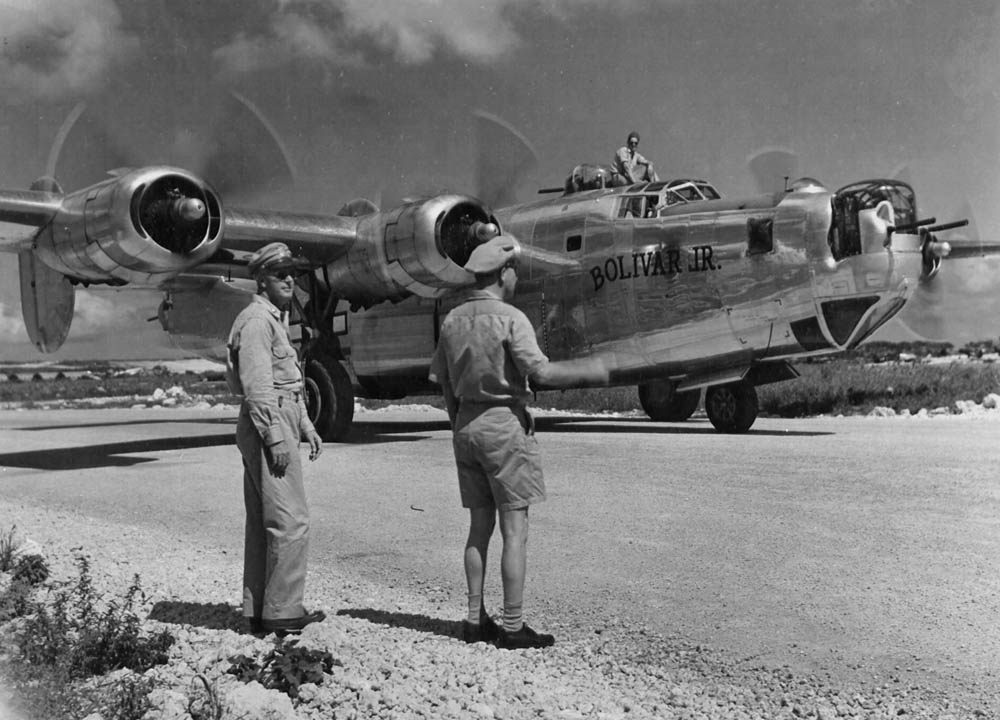 Two officers watch the B-24 Liberator "Bolivar Jr." of 431st BS, 11th BG taxi to a hardstand, May 1945. (U.S. Air Force Photograph.)