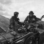 Two U.S. fighter pilots from 9th Air Force examine a wrecked German Me 109 fighter.