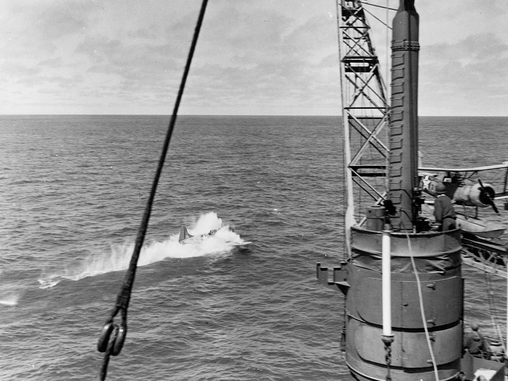 A Douglas SBD Dauntless from VB-3 ditches near the heavy cruiser USS Astoria (CA-34) after attacking Japanese aircraft carriers during the Battle of Midway, June 1942.