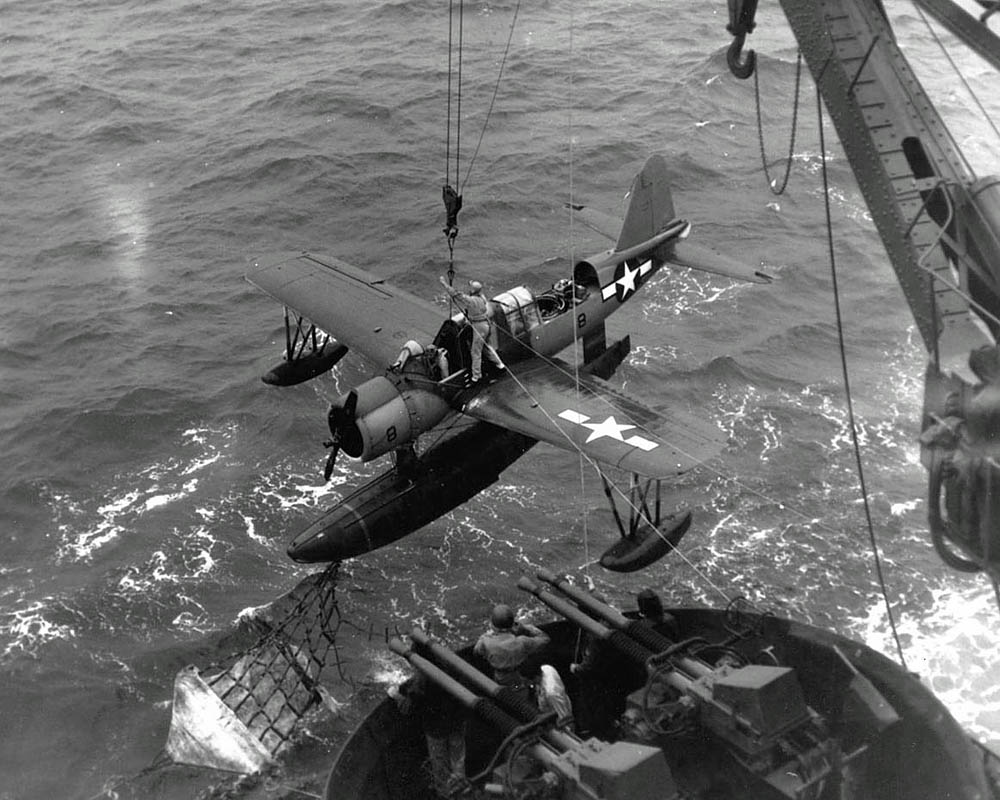 A Vought OS2U Kingfisher is recovered by the U.S. Navy battleship USS Texas off the shore of Iwo Jima in February 1945. (U.S. Navy Photograph.)