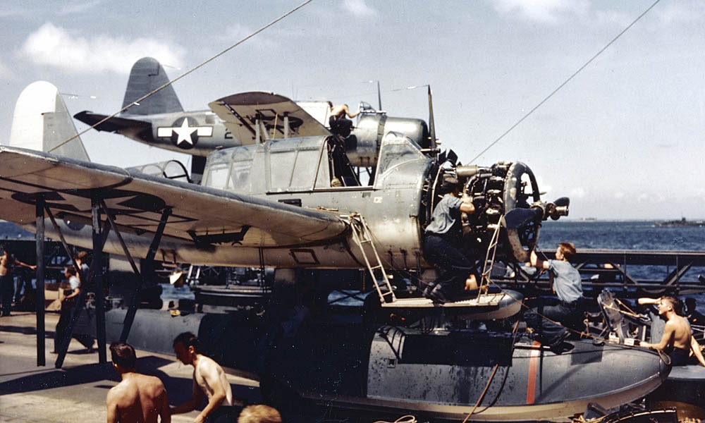 Vought OS2U Kingfisher floatplanes receive maintenance and engine overhauls on the deck of the battleship USS South Dakota (BB-57) during World War II. (U.S. Navy Photograph.)