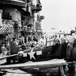 Sailors watch aircraft from the Carrier Air Group 12 (CVG-12) landing on the flight deck of the U.S. Navy aircraft carrier USS Saratoga (CV-3).