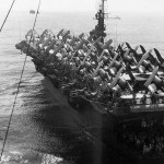 The escort carrier USS Attu (CVE-102), loaded with Vought F4U Corsairs on the flight deck, photographed alongside the Clemson-class destroyer USS Fox, September 1945.