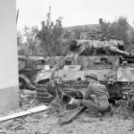 A British soldier takes cover in front of a knocked-out German Panzer III in Oosterhout near Nijmegen, September 1944. (Imperial War Museum Photograph.)