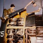 Sailors perform engine maintenance on a Grumman F6F Hellcat on the USS Yorktown somewhere in the Pacific. (U.S. Navy Photograph.)