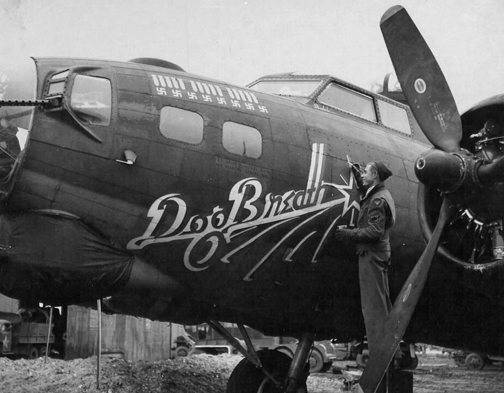 The Boeing B-17 Flying Fortress "Dog Breath" of the 452nd Bomb Group receives a touchup on its nose art in England in April 1944. (U.S. Air Force Photograph.)