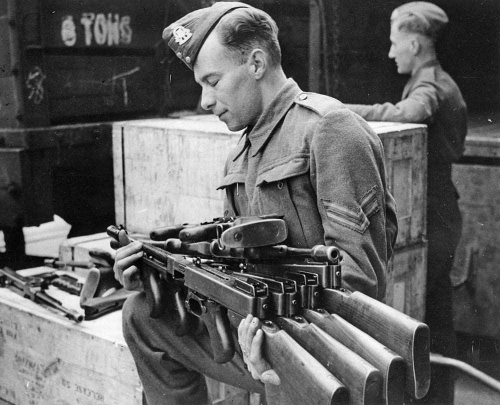 Lend-lease Thompson submachine guns arriving in England are unpacked by an ordnance corporal. (U.S. National Archives Photograph.)