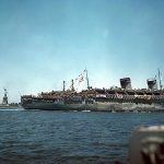 Loaded with troops returning from Europe, USS West Point passes the Statue of Liberty outisde New York City, July 1945. (U.S. Navy Photograph.)