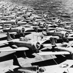 In the foreground, Grumman F4F-3 Wildcats of VF-3, Felix the Cat, are parked on the flight deck of the USS Saratoga. In the background, Douglas SBD-3 Dauntless and Douglas TBD-1 Devastator aircraft are pictured. (U.S. Navy Photograph.)