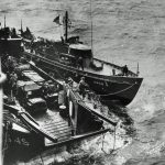 The U.S. Coast Guard cutter USCG-1 waits off Omaha Beach on the morning of D-Day tied up alongside an LCT. (U.S. Coast Guard Photograph.)