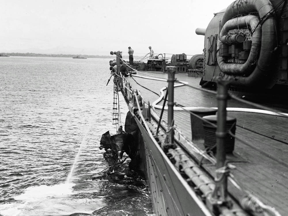 Sailors repair torpedo damage to the heavy cruiser USS Chicago (CA-29) near Guadalcanal after the Battle of Savo Island in August 1942. (Official U.S. Navy Photograph.)