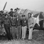 Pilots and airmen from the 64th Fighter Squadron of the 57th Fighter Group pose for a photograph in front of a unit fighter. (Library of Congress Photograph.)