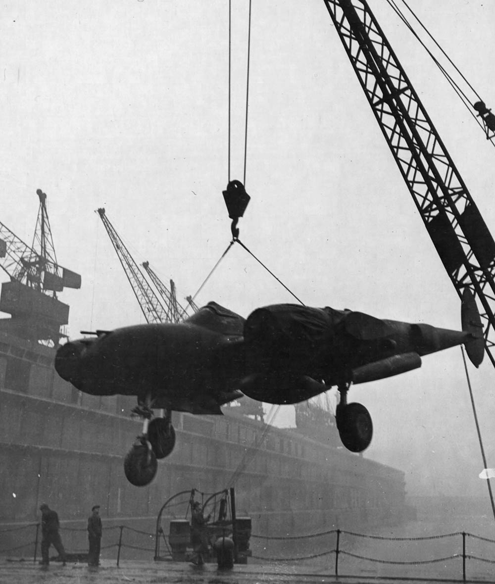 A Lockheed P-38 Lightning fighter is unloaded by crane from a ship at Queens Dock, Liverpool in January 1943. (U.S. Air Force Photograph.)