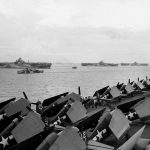 Hellcats and Avengers on the flight deck of the carrier USS Ticonderoga (CV-14) are shown in the foreground of the U.S. Navy aircraft carriers USS Wasp (CV-18), USS Yorktown (CV-10), USS Hornet (CV-12), and USS Hancock (CV-19) anchored in Ulithi Atoll. (U.S. Navy Photograph.)