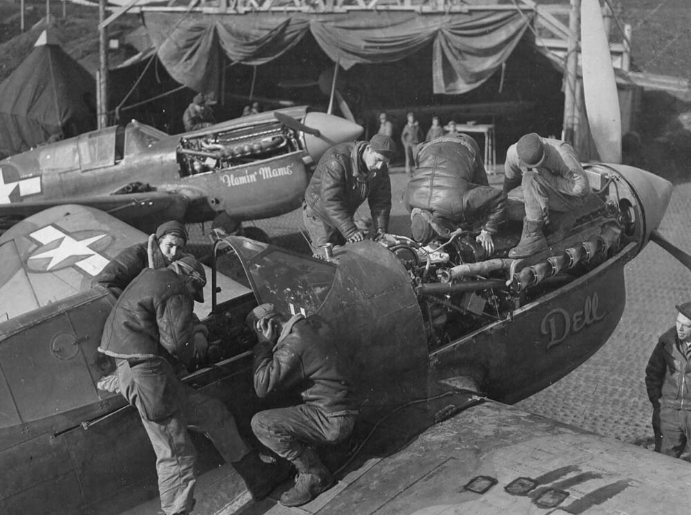 Two Curtiss P-40 Warhawk fighters -- named "Dell" and "Flamin' Mame" -- undergo repairs on Amchitka Island in the Aleutian Islands in October 1943. (U.S. Air Force Photograph.)