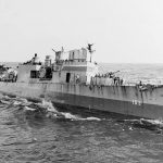 A signalman atop the Wickes-class destroyer USS Bernadou (DD-153) sends a semaphore message while at sea during the Invasion of North Africa, November 1942. (U.S. Navy Photograph.)