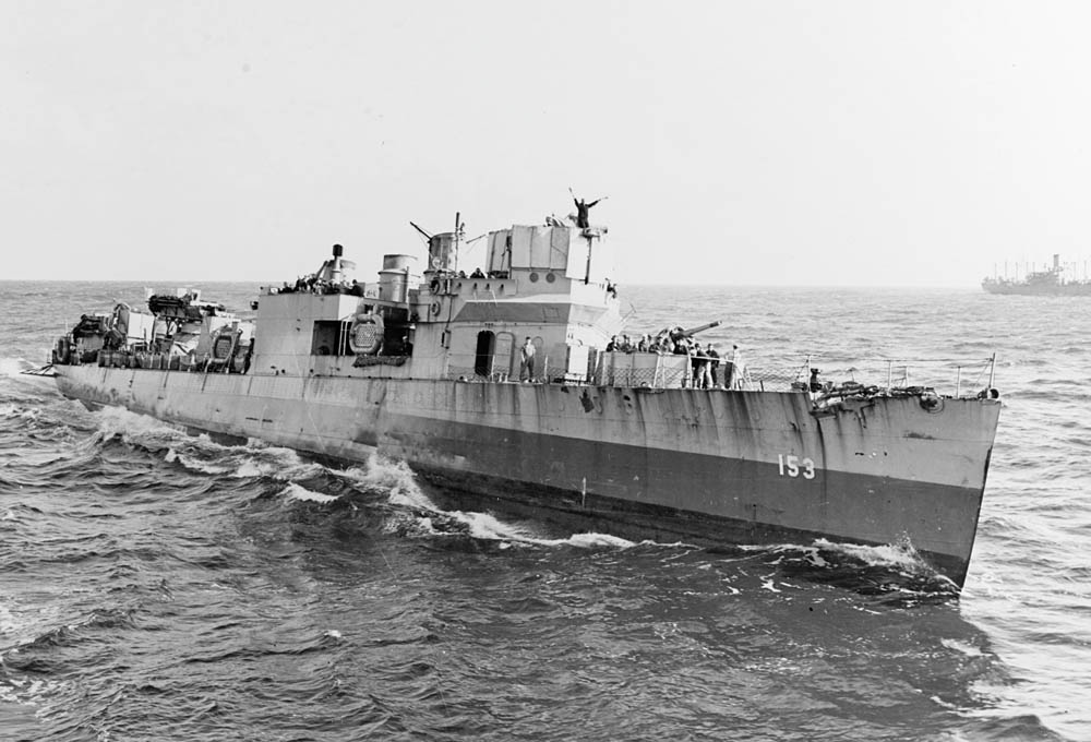 A signalman atop the Wickes-class destroyer USS Bernadou (DD-153) sends a semaphore message while at sea during the Invasion of North Africa, November 1942. (U.S. Navy Photograph.)